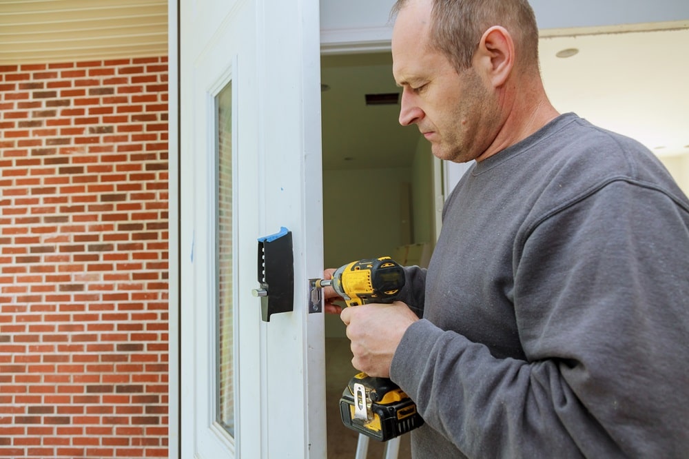 Installation locked interior door woodworker hands install lock Installation of the door lock.