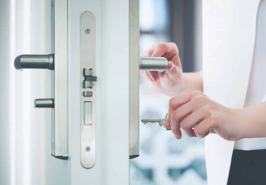 Locking or unlocking modern door with key in hand